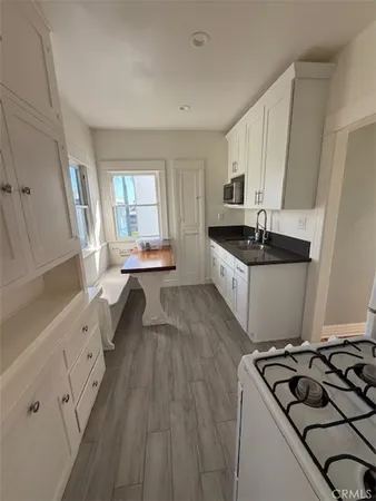a kitchen with granite countertop a sink stove and cabinets