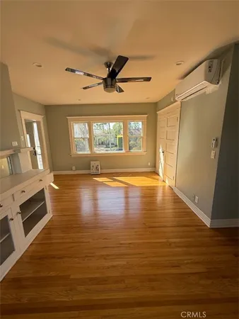 a view of a livingroom with wooden floor and a window