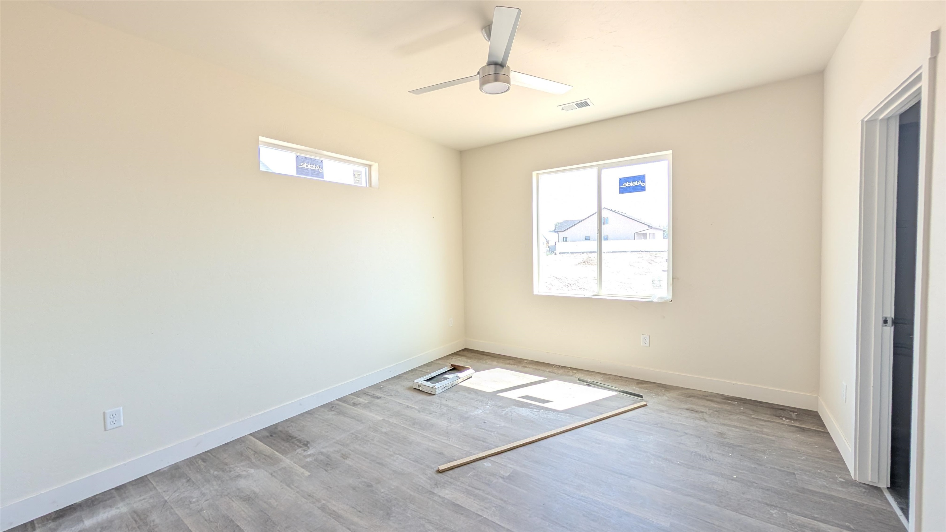 2452 Hamilton Road, Unit A Grand Junction, CO 81505 - Photo 9 of 13 an empty room with wooden floor windows and fan