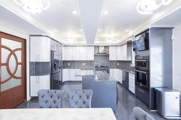 a kitchen with stainless steel appliances kitchen island granite countertop a refrigerator and stove