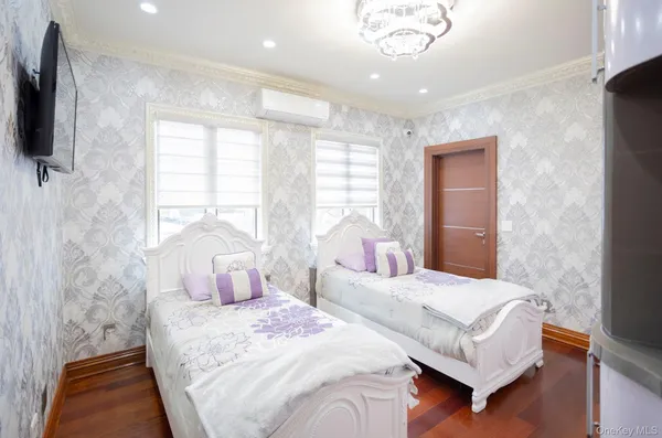 a bedroom with a bed a flat screen tv and windows