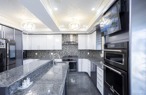 a large kitchen with stainless steel appliances granite countertop a stove and a sink