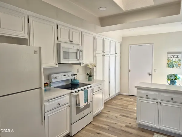 a kitchen with white cabinets and white appliances