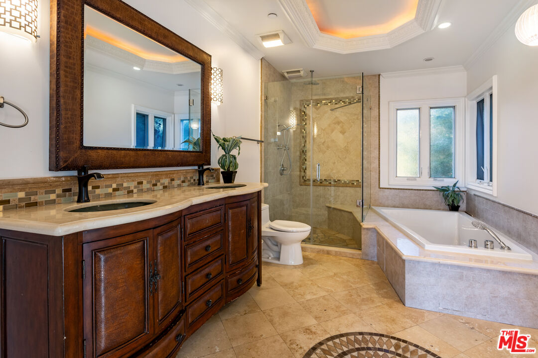 1491 Carla Ridge Beverly Hills, CA 90210 - Photo 48 of 63 a spacious bathroom with a granite countertop tub sink a mirror a bathtub and shower