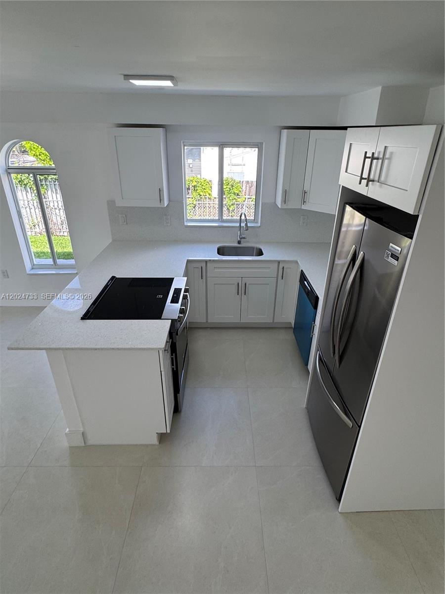 3305 Southwest 28th Street, Unit 3305 Miami, FL 33133 - Photo 5 of 17 a kitchen with a refrigerator and a sink
