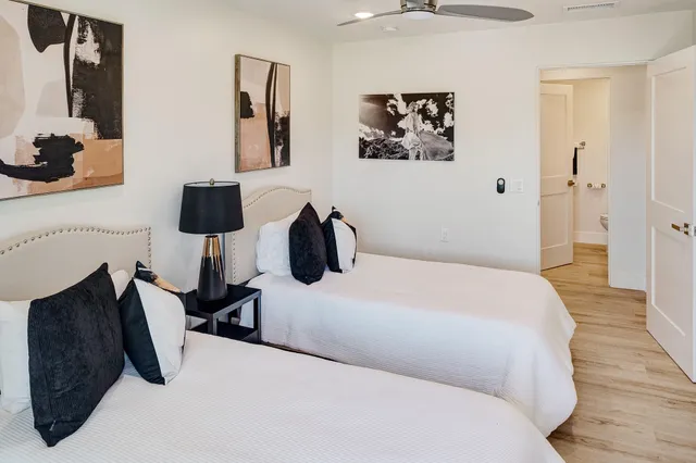 a bedroom with a bed and a lamp on dresser