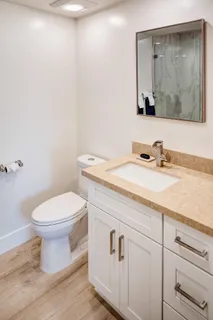 a bathroom with a sink a toilet and mirror