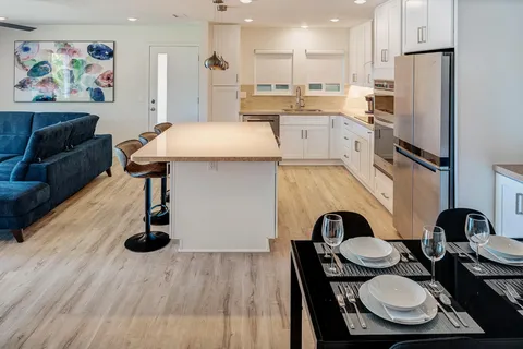 a kitchen with stainless steel appliances refrigerator dining table and chairs