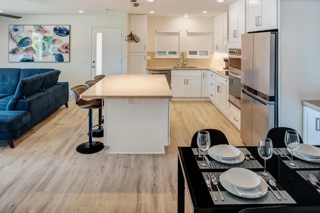 a kitchen with stainless steel appliances refrigerator dining table and chairs