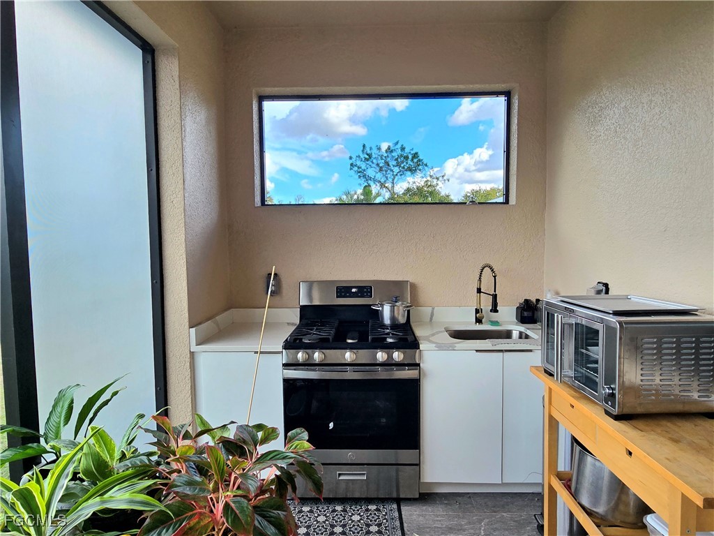 705 Harding Lane Lehigh Acres, FL 33936 - Photo 29 of 38 a kitchen with stainless steel appliances a stove and a microwave