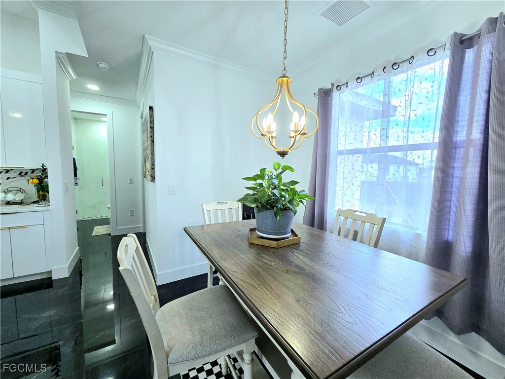 705 Harding Lane Lehigh Acres, FL 33936 - Photo 10 of 38 a view of a dining room with furniture and a potted plant