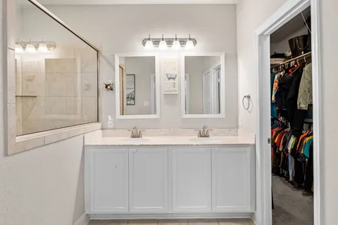 a bathroom with a granite countertop sink a mirror and a shower