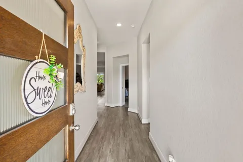 a view of a hallway with wooden floor