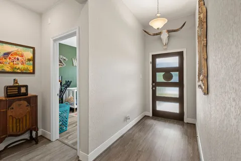 a view of a livingroom with wooden floor and a flat screen tv