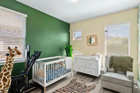 a bedroom with a baby bed a couch and dresser