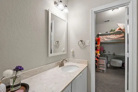a en suite bathroom with a granite countertop sink and a mirror