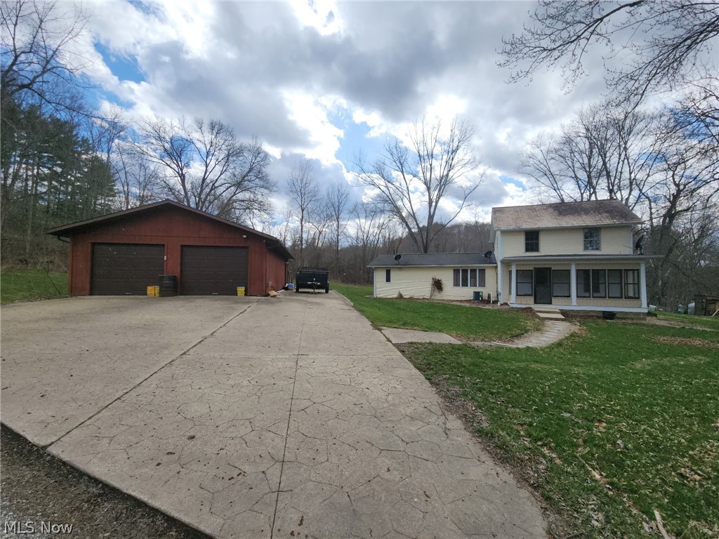 6784 Old Zoarville Road Northeast Dover, OH 44622 - Photo 1 of 50 View of home's exterior featuring an outdoor structure, a detached garage, a yard, and covered porch