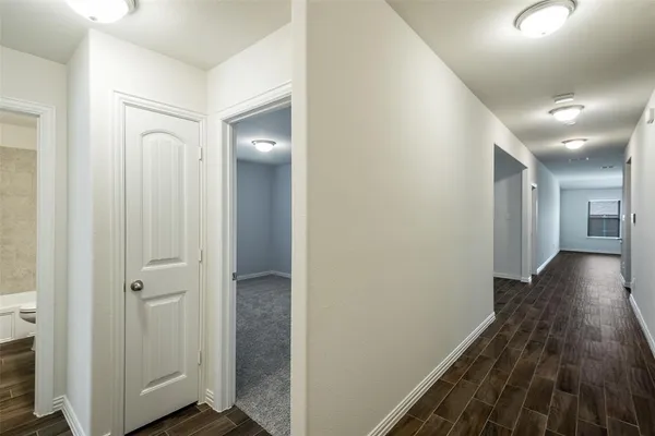 a view of a hallway with wooden floor
