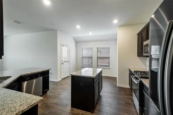 a kitchen with stainless steel appliances granite countertop a sink dishwasher stove and refrigerator