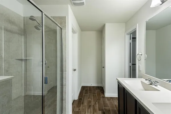 a bathroom with a shower sink and mirror