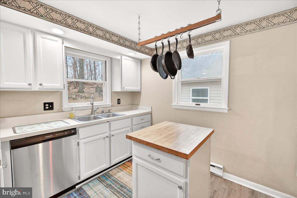 9505 Cabbage Run Road Frederick, MD 21701 - Photo 16 of 50 a kitchen with a sink dishwasher and white cabinets with wooden floor