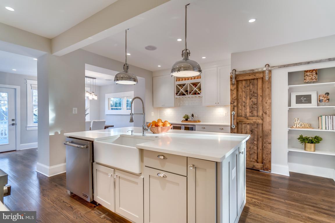 2211 38th Street Northwest Washington, DC 20007 - Photo 12 of 51 a kitchen with kitchen island a sink a stove a dining table and chairs