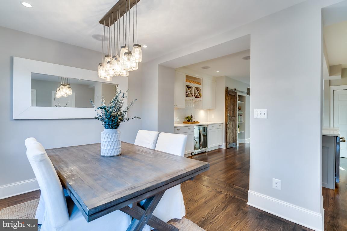 2211 38th Street Northwest Washington, DC 20007 - Photo 16 of 51 a dining room with wooden floor a chandelier a wooden table and chairs