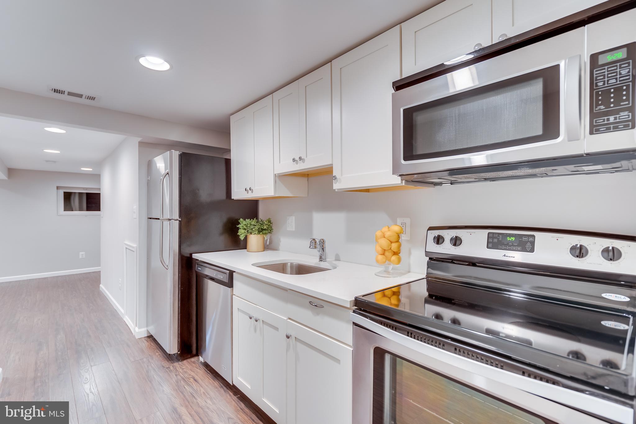 2211 38th Street Northwest Washington, DC 20007 - Photo 29 of 51 a kitchen with stainless steel appliances a stove microwave and sink