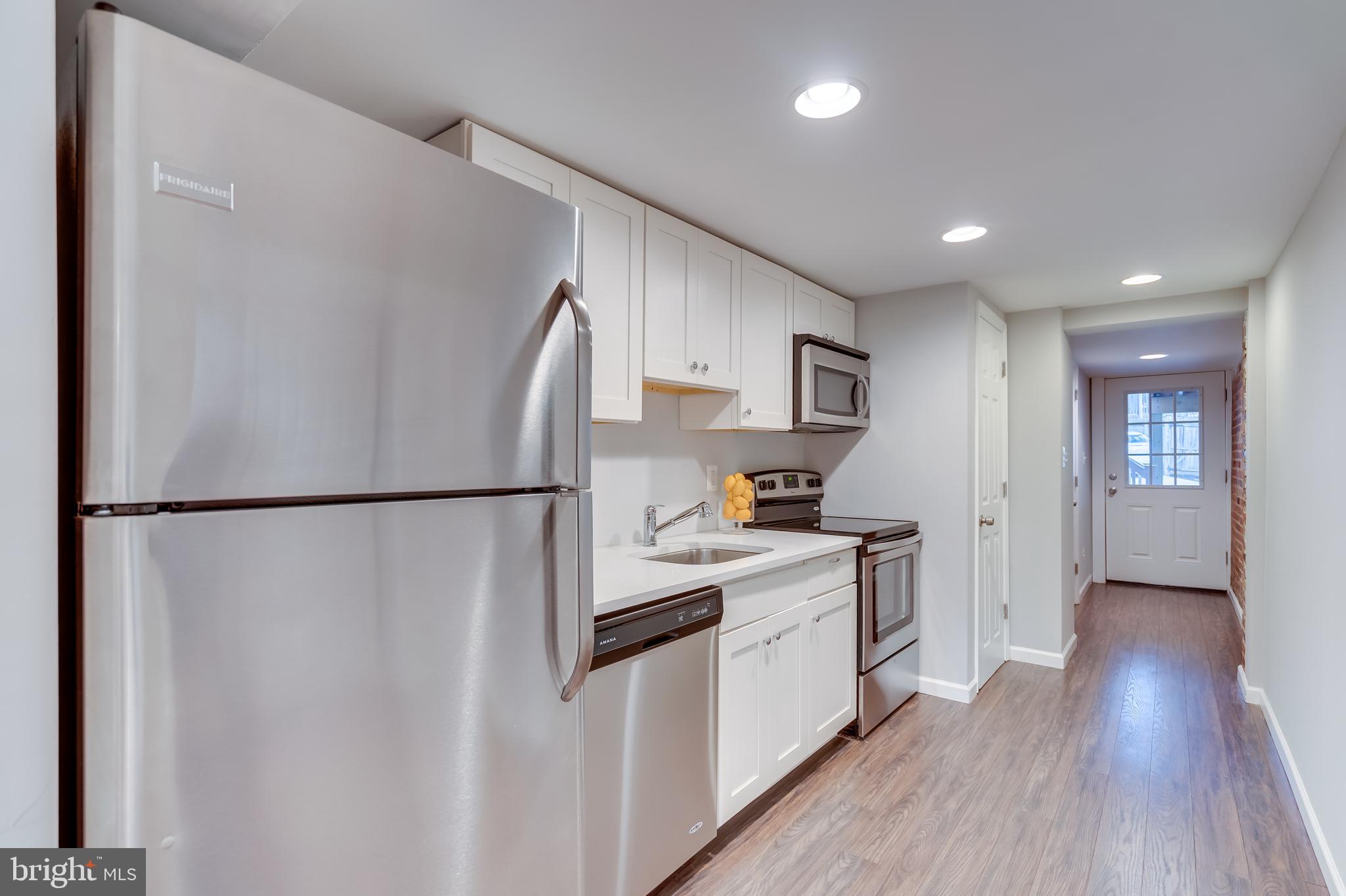 2211 38th Street Northwest Washington, DC 20007 - Photo 30 of 51 a kitchen with white cabinets and white appliances