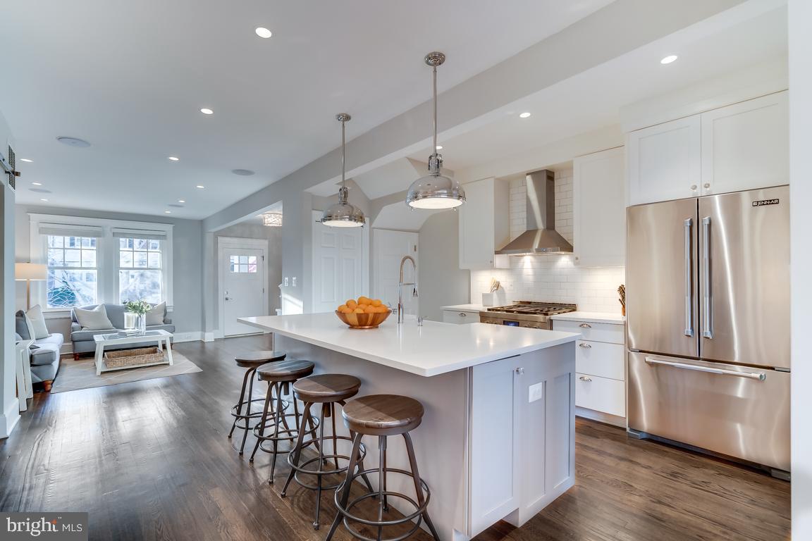 2211 38th Street Northwest Washington, DC 20007 - Photo 8 of 51 a kitchen with a refrigerator a stove a sink a dining table and chairs with wooden floor