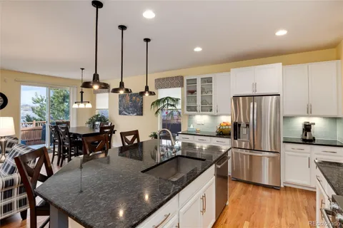 a kitchen with stainless steel appliances granite countertop sink stove and refrigerator