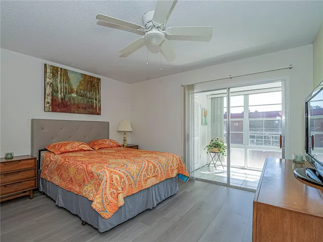 a bedroom with a bed and a flat tv screen on dresser