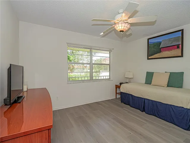 a bedroom with a large bed chandelier and a window