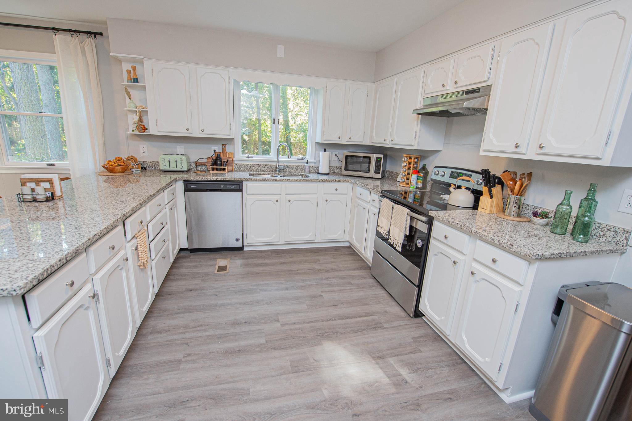 414 Pine Bluff Road Salisbury, MD 21801 - Photo 31 of 91 a kitchen with kitchen island granite countertop lots of white cabinets and wooden floor