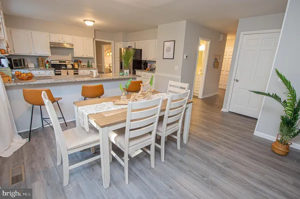 a living room with a table chairs and a wooden floor