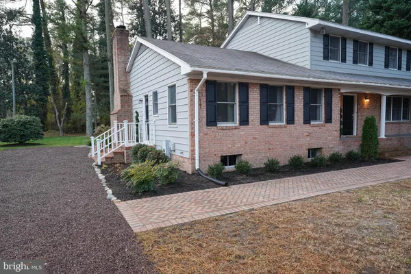 a view of a house with backyard and trees