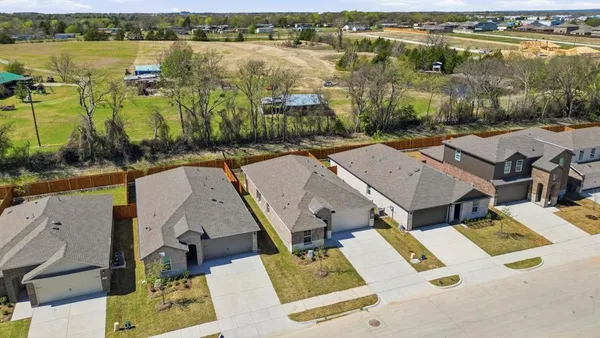 an aerial view of residential houses with outdoor space and lake view