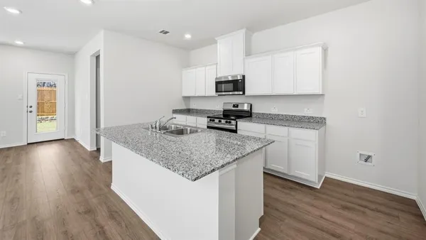 a kitchen with stainless steel appliances granite countertop a sink a refrigerator and a granite counter tops