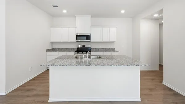 a kitchen with stainless steel appliances granite countertop a sink stove and refrigerator