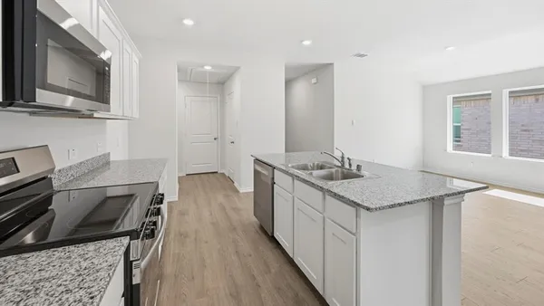 a kitchen with stainless steel appliances granite countertop a stove and a microwave