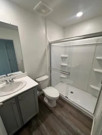 a large kitchen with a center island wooden floor stainless steel appliances and cabinets