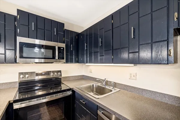 a kitchen with wooden cabinets a sink and a stove