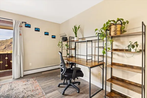 a view of a workspace with furniture and wooden floor
