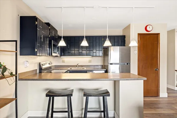 a kitchen with stainless steel appliances granite countertop a sink and a refrigerator