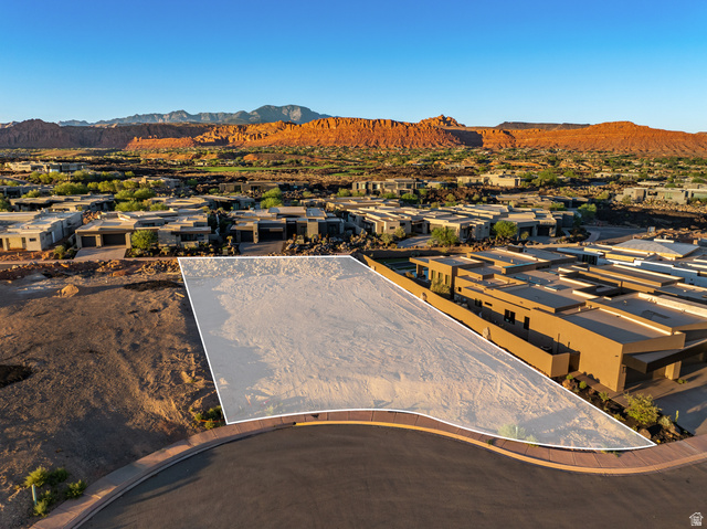 0 St. George, UT 84770 - Photo 7 of 25 Expansive lot with a curved road frontage, surrounded by modern residences, and featuring distant mountainous scenery