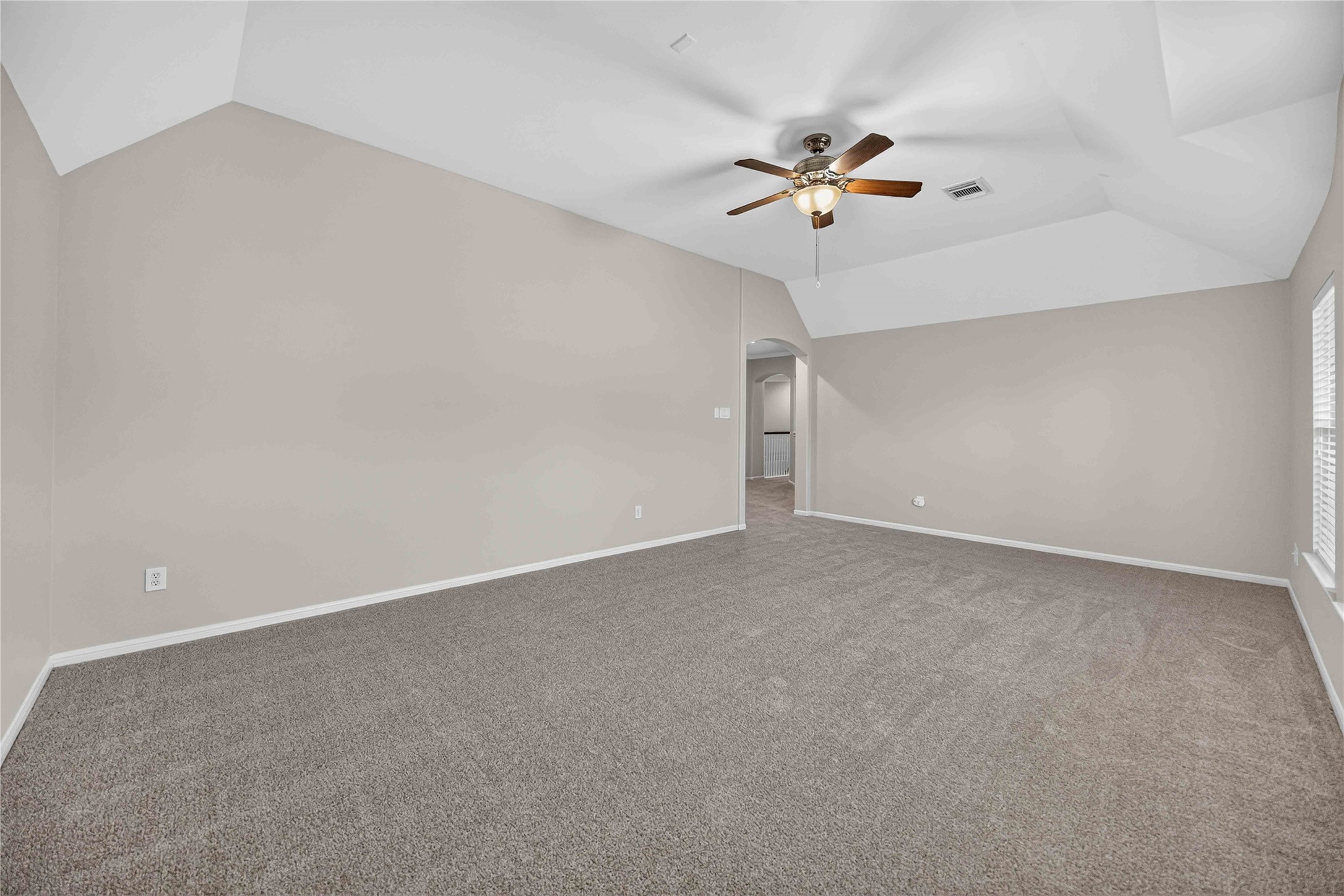 3303 Raleigh Row Missouri City, TX 77459 - Photo 44 of 50 Spacious Gameroom with a vaulted ceiling, plush carpeting, and ample natural light from a large window, perfect for relaxation or entertainment.