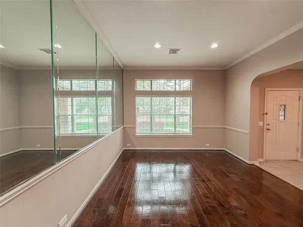 a view of empty room with wooden floor and fan