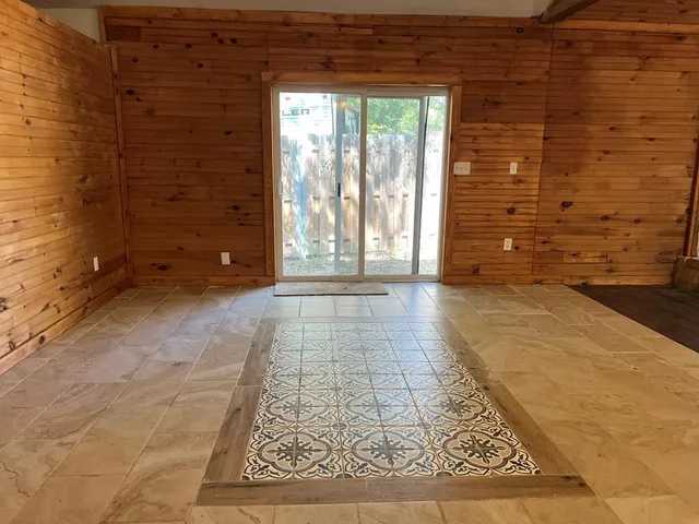 a view of an empty room with a door and a rug