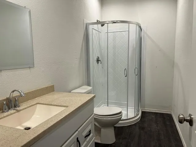 a bathroom with a granite countertop sink toilet and shower
