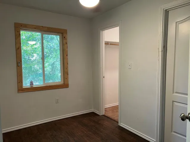 an empty room with wooden floor and a window